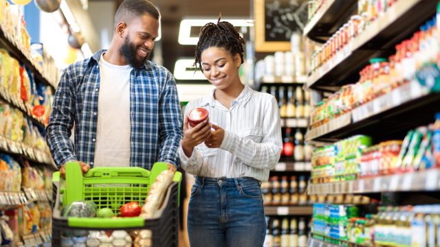 Happy couple smiling as they grocery shop.