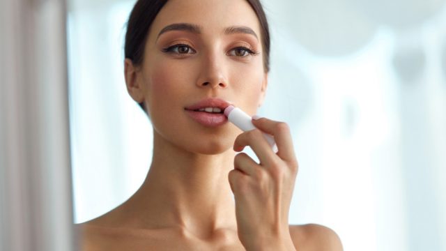 Woman applying lip balm