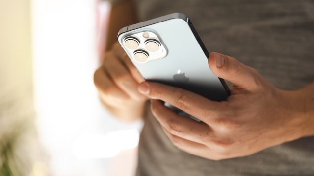 Man using New iPhone 13 Pro in SIerra blue color, close-up to camera set