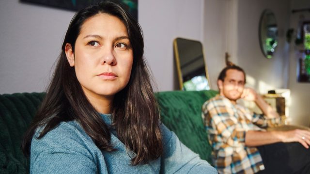 Cropped shot of an attractive young woman looking annoyed after arguing with her boyfriend who is sitting in the background