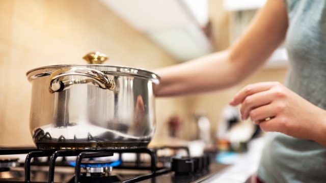 white woman cooking with a gas stove