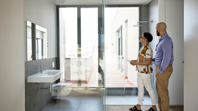 A couple of homebuyers looking at a modern bathroom in a house