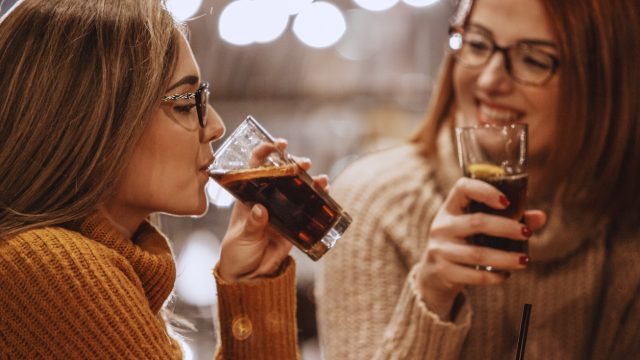 Close-up shot of two women having a soda