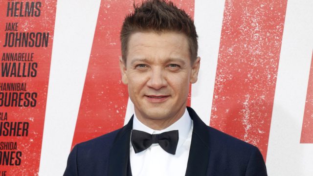 A headshot of Jeremy Renner wearing a tuxedo at a red carpet event