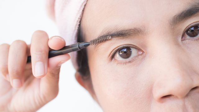 Close up of woman filling in eyebrows