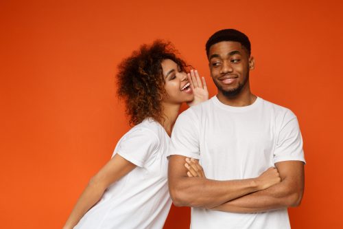 woman whispering a funny compliment to a man