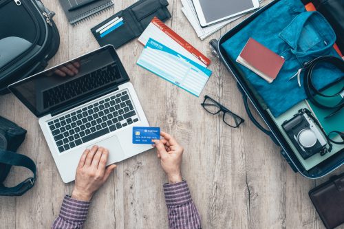 man booking travel on the computer with his credit card