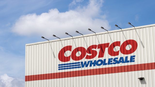 A close crop of a Costco sign on the side of a warehouse location