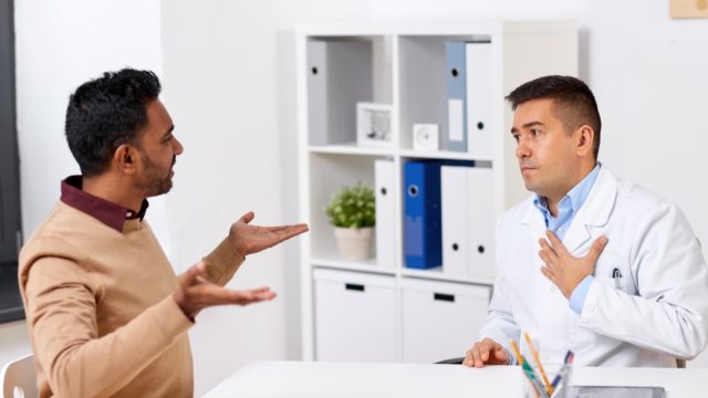 doctor and displeased male patient arguing at clinic