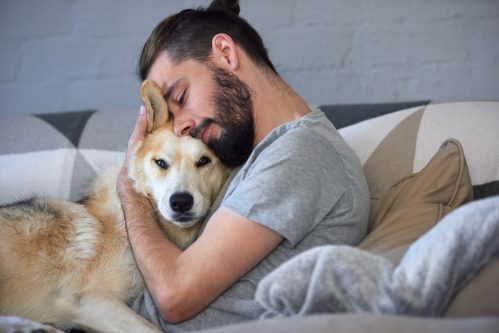 man hugging dog