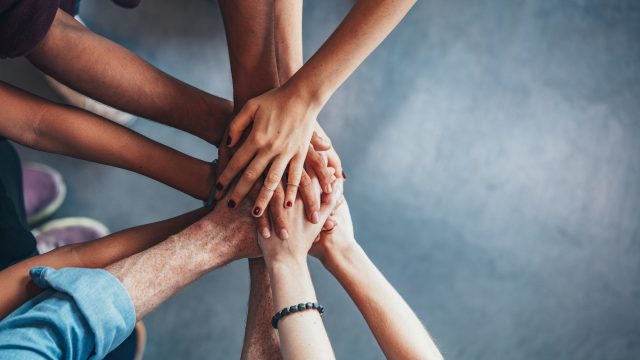 coworkers putting their hands together