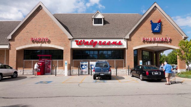Customers outside a Walgreens drug store on a summer day