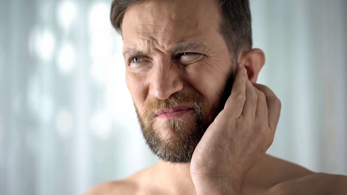 Man feeling ear pain