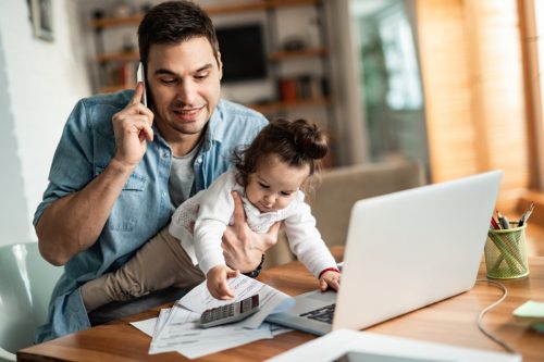 man on phone while holding a baby