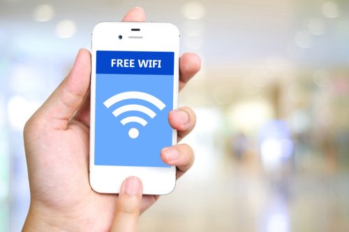 Hand holding smart phone with free wifi on screen