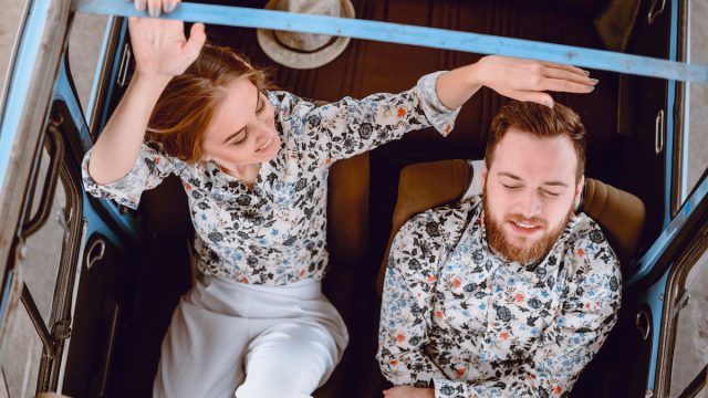 Happy couple in a vintage car wearing matching shirts