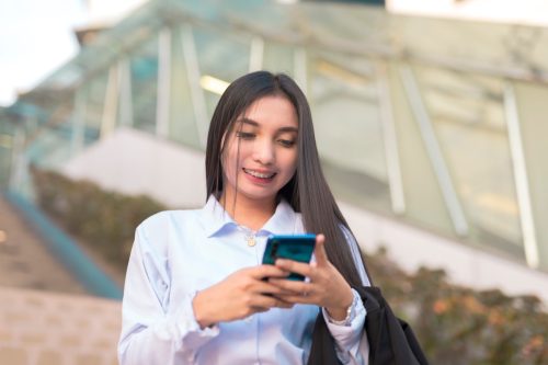 woman texting her boyfriend something cute after leaving work