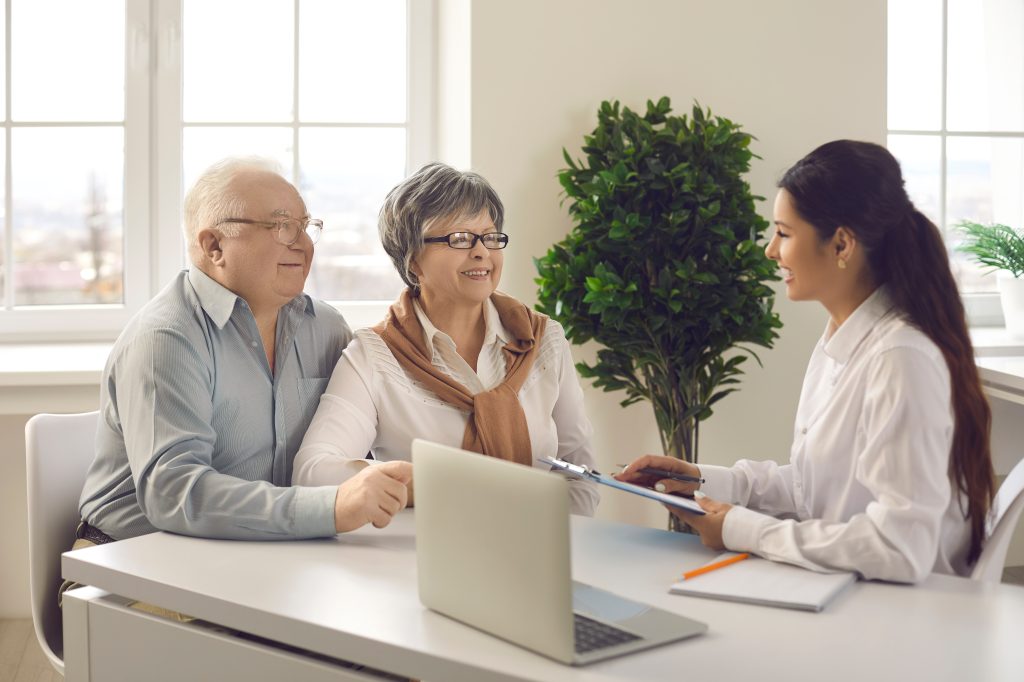 Man and woman speak to female tax preparer in an office