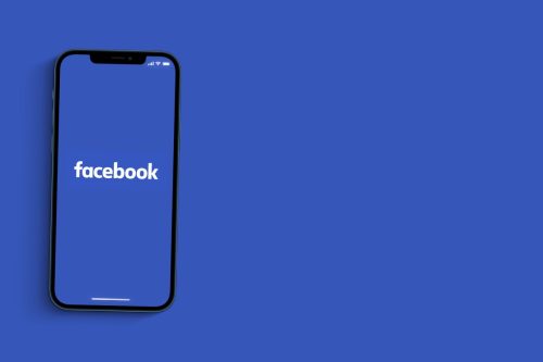 facebook app open on smartphone on blue background