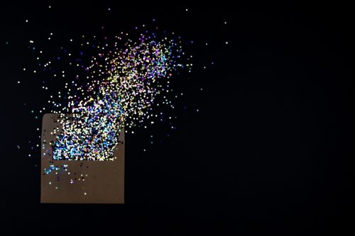 glitter exploding out of a black envelope