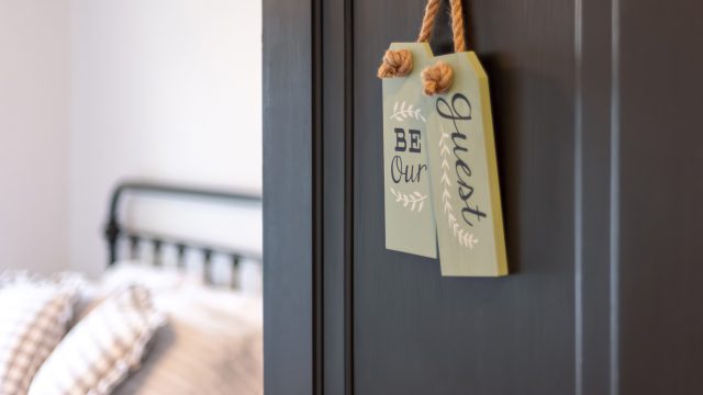 Guest bedroom with 'be our guest' sign on door