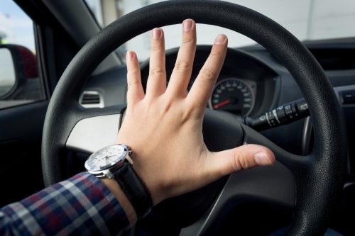 man honking the horn of his car