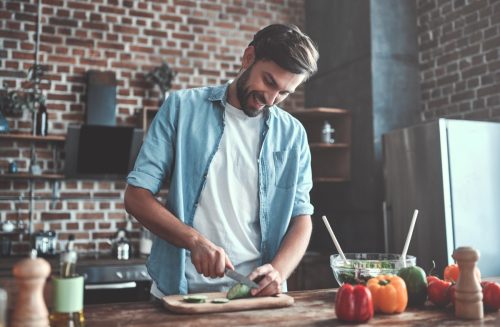 young man cooking dinner for his fmaily