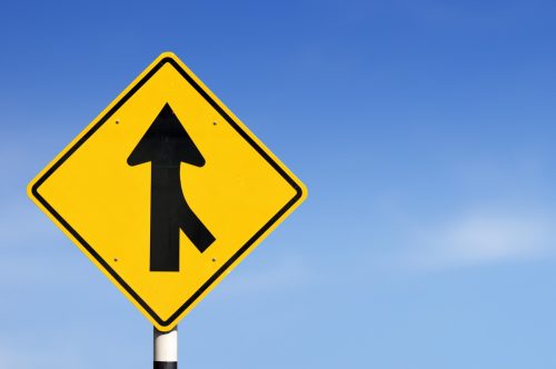 Merge road sign on sky background.