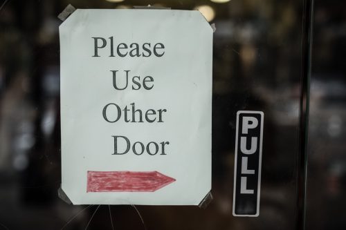 sign on door that says "please use the other door"