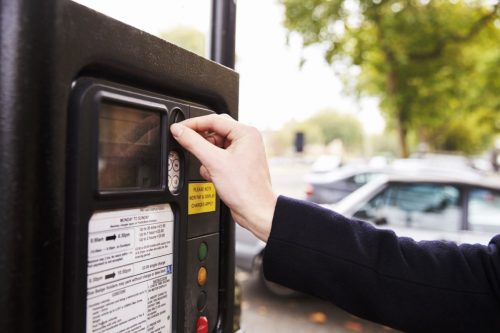 putting money in a parking meter