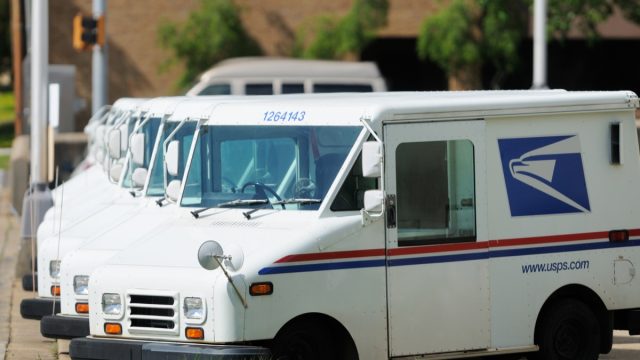 Line of United States Postal Service USPS delivery vehicles or vans in a parking lot. Corner of 9th street and 22nd avenue in downtown Meridian, MS.