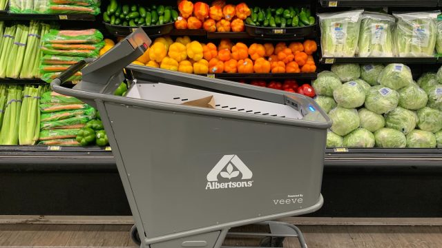 Product image of an Albertson's smart shopping cart made by Veeve in front of a produce display