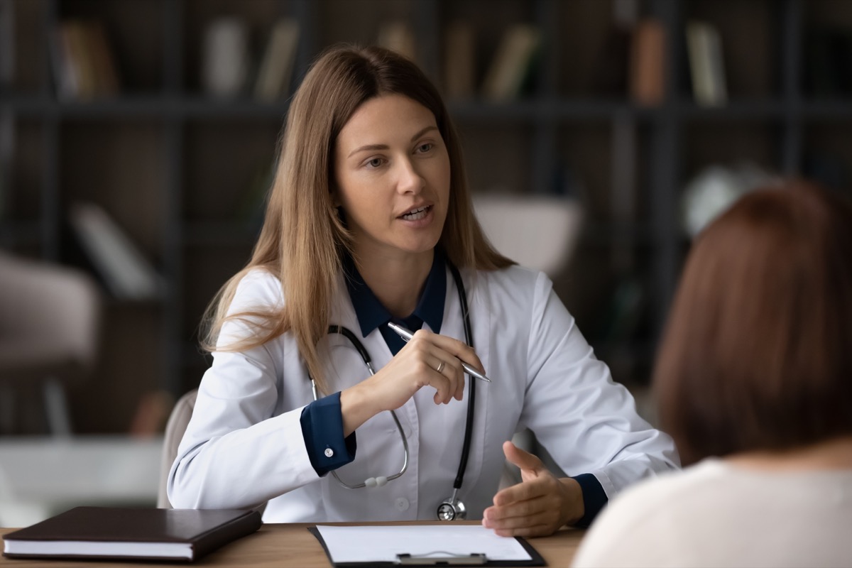 Female doctor consulting woman patient sitting at desk