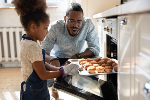 father and daughter cooking muffins
