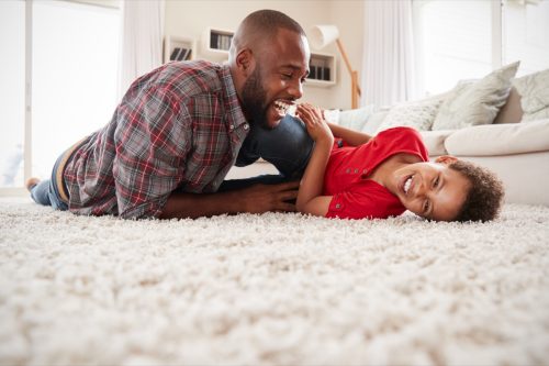 father and son exchanging funny jokes in the living room