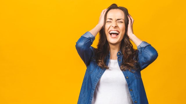 woman putting her fingers through her hair while laughing hysterically