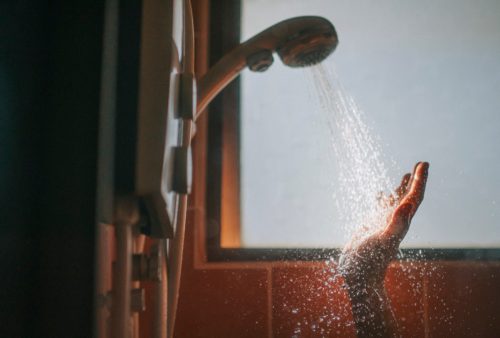 morning beginning of the day backlit sunlight bathroom female washing her hand with running water