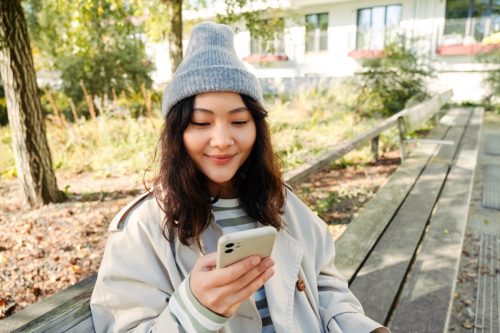 woman smiling looking at her phone