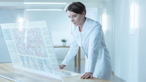 futuristic image of a female scientist deciphering sequenced human DNA