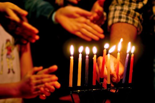 jewish family celebrating the last night of hanukkah