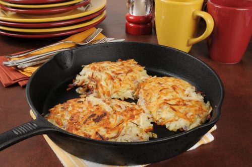 Golden fried potato latkes in a cast iron skillet