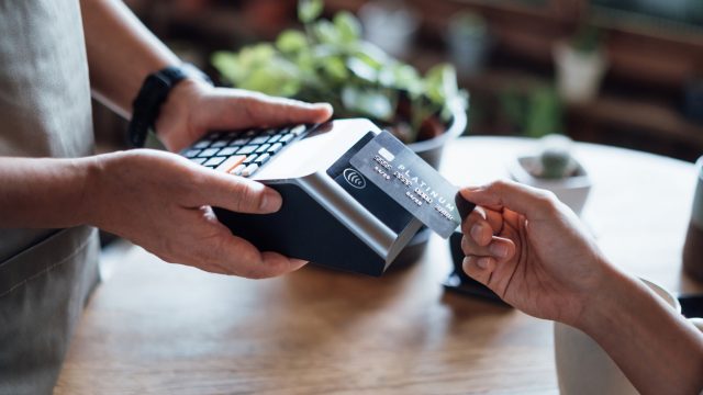 A close up of someone tapping their debit or credit card during a purchase at a store