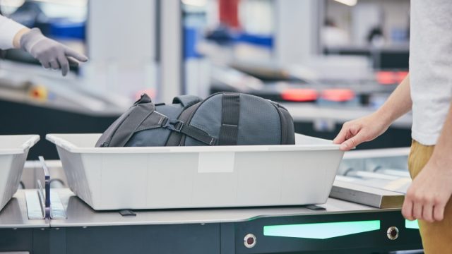 traveler putting bag through airport security