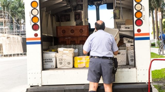 Postman unloading the truck delivering the mail in Miami, Fl. In the more than two centuries since Benjamin Franklin was appointed US first Postmaster General in 1775, the Postal Service™ has grown and changed with America, boldly embracing new technologies to better serve a growing population.