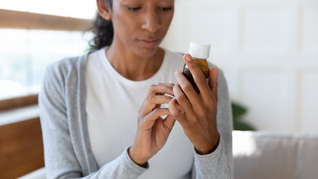 A woman checking the label of a medicine bottle