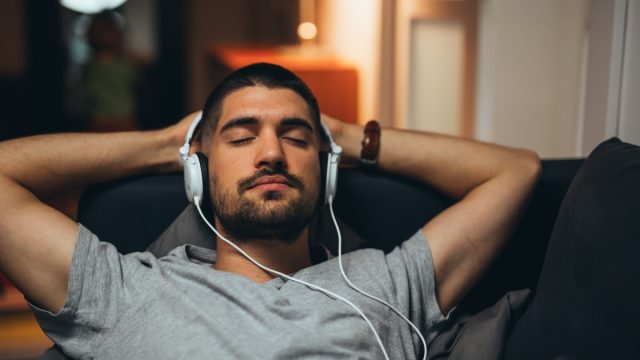 Man Laying Back with Headphones On