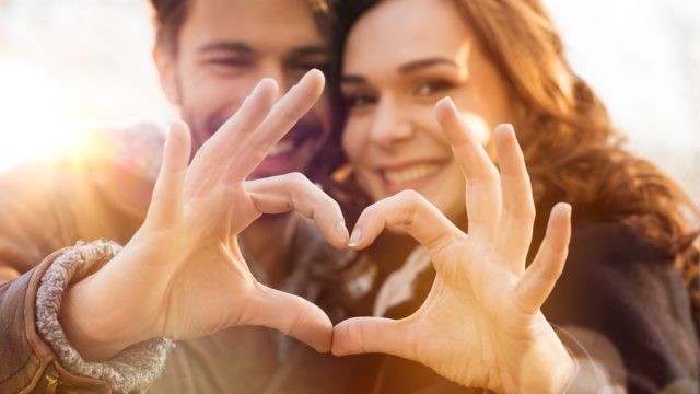 Closeup of couple making heart shape with hands