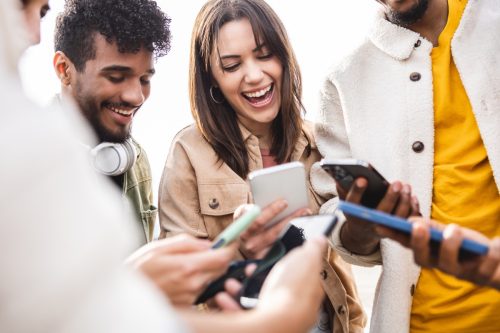 group of friends laughing, on their phones