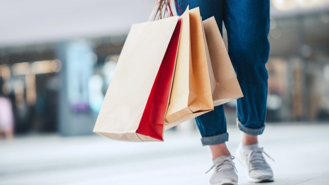 Woman holding sale shopping bags. Consumerism, shopping, lifestyle concept