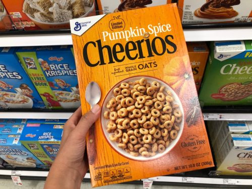 Hand holding Pumpkin Spice Cheerios in supermarket
